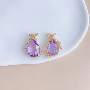 Close-up of teardrop purple crystal pendant with gold setting and zircon accents