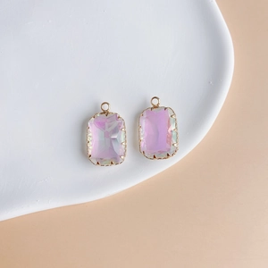 Close-up of pink gradient rectangular gemstone pendants with gold plated copper borders
