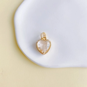 Détail du pendentif en cristal en forme de cœur avec sertissage en cuivre doré poli