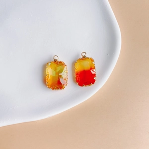 Macro detail of geometric rectangular pendants with warm yellow to red gradient facets