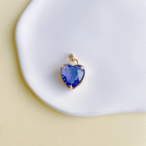Détail macro du pendentif cœur en pierre précieuse violette avec monture dorée