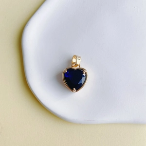 Détail macro du pendentif cœur en pierre bleue avec sertissage et bélière en cuivre doré