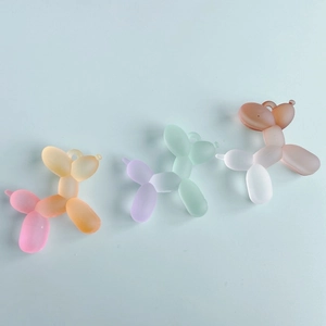 Close-up of frosted resin balloon dog charms with dual-tone gradient colors for DIY crafts