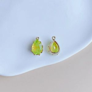 Vue détaillée des pendentifs en cristal goutte vert avec bordure en métal doré