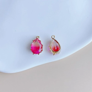 Détail de pendentifs en cristal goutte avec dégradé rose et sertissage en métal doré