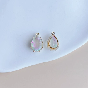 Détail de pendentifs en cristal goutte avec finition irisée et bordure dorée élégante