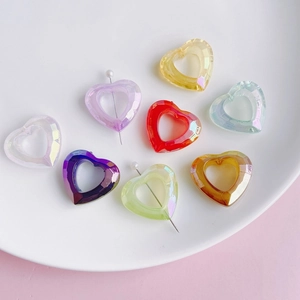 Colorful faceted resin heart pendants in a white ceramic dish for DIY jewelry making