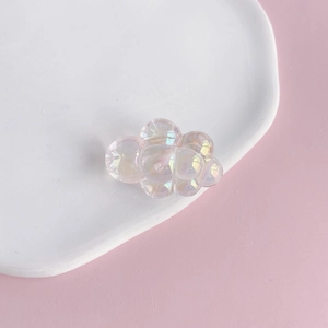 Detail of translucent iridescent acrylic chubby cloud charm with colorful rainbow luster