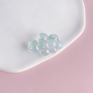 Macro detail of translucent acrylic cloud charm with iridescent pearl luster for DIY crafts