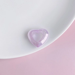 Detailed view of a translucent lavender acrylic heart ring on a white ceramic plate