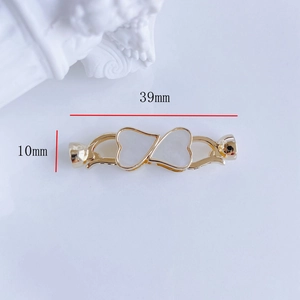 Détail macro du connecteur de 39mm en plaqué or avec nacre en forme de cœur et zircon