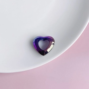 Macro shot of iridescent heart-shaped acrylic resin pendants on a pink surface