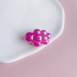 Close-up of rose pink iridescent bubble grape charms for DIY keychains and jewelry