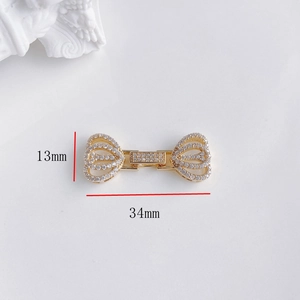 Dettaglio del connettore a fiore placcato oro con zirconi, misura 34 mm per 13 mm