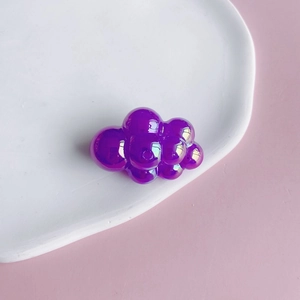 Macro shot of iridescent purple cloud-shaped DIY accessory with glossy finish