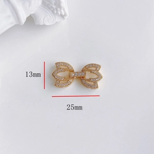 Dettaglio macro del connettore a fiocco dorato 25x13mm con pavé di zirconi per gioielli