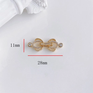 Dettaglio macro del connettore a fiocco dorato da 11x28mm con zirconi cubici luccicanti