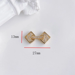 Dettaglio del connettore dorato 13x27mm con fiori e fiocchi decorati con zirconi