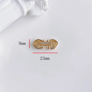 Dettaglio del connettore a fiocco dorato 23x9mm con zirconi per creazione gioielli DIY