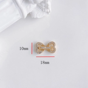 Dettaglio macro del connettore fiocco dorato da 18mm con zirconi incastonati