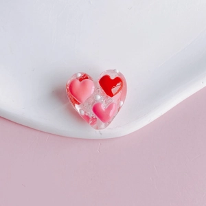 Detail of pink transparent heart bead with red polka dots and inner heart patterns