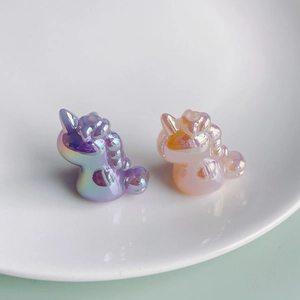 Close-up of iridescent unicorn charms in purple and orange with pearlescent finish