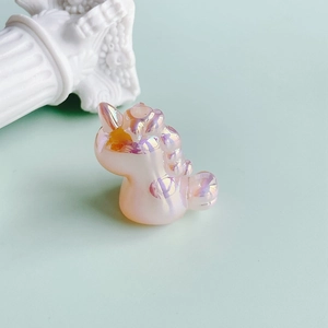 Macro detail of iridescent resin unicorn charm with a pearlescent pink finish for DIY crafts
