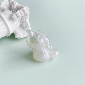 Macro view of iridescent unicorn pendant with pearlescent finish for DIY jewelry crafting