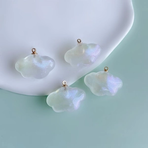 Gros plan de pendentifs nuages DIY avec finition nacrée et anneaux métalliques dorés