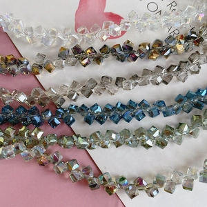 Macro detail of cube-cut faceted glass crystal beads in diverse iridescent finishes