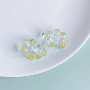 Close-up of DIY flower-shaped glass beads with yellow and cyan polka dot patterns