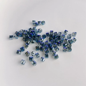 Macro detail of cube-cut blue crystal glass beads with AB iridescent finish for DIY jewelry