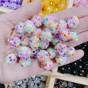 Gros plan de perles en résine colorées avec strass pour création de bijoux DIY