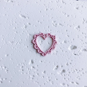 Detail of pink hollow heart charm with scalloped edges for DIY jewelry making