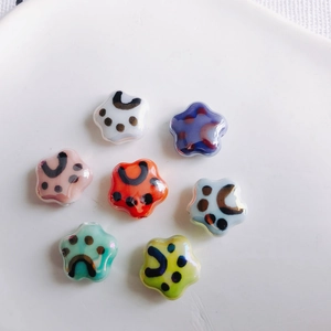 Flat lay of colorful star-shaped ceramic beads with cute paw prints for DIY jewelry