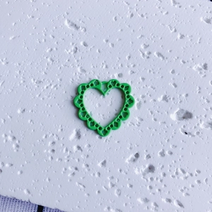 Macro shot of an emerald green hollow heart pendant for DIY jewelry crafts