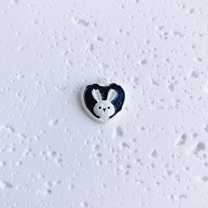 Detailed view of a black and white heart-shaped bunny pendant for DIY jewelry making