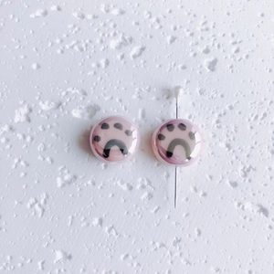 Detail of pink ceramic round beads with black cat paw prints and smooth glazed finish