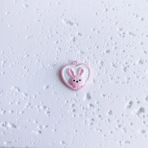 Detail of pink heart pendant featuring cute rabbit relief and top ring for DIY jewelry