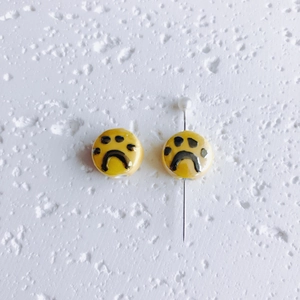Vue détaillée de perles en céramique jaunes avec empreintes et trou de perçage