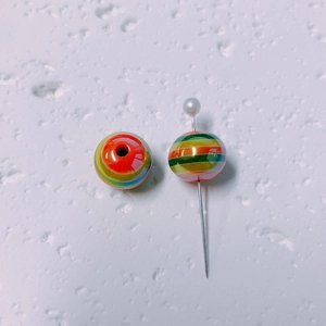 Macro shot of colorful striped lollipop aurora beads and metal pins for DIY jewelry making
