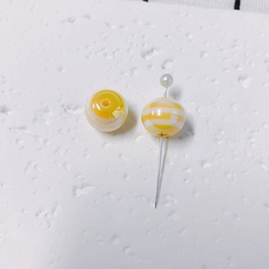 Detailed view of yellow and white striped lollipop bubble beads for DIY jewelry making
