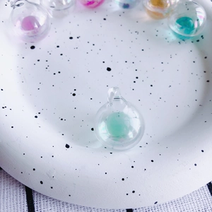 Nahaufnahme von mintgrünem schillerndem Glasanhänger mit transparenter Öse für DIY Schmuck