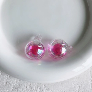 Nahaufnahme von irisierenden rosa Glasanhängern für DIY-Schmuck und Ohrringe