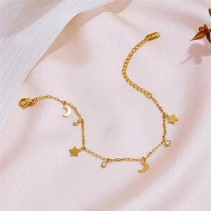 Minimalistisches Armband aus Gold-Edelstahl mit Stern, Mond und Zirkon auf rosa Satin