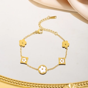 Golden titanium steel bracelet with white clover charms and polished lobster clasp