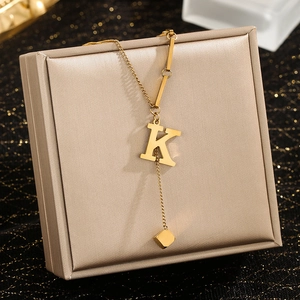 Minimalist gold stainless steel necklace featuring a K letter pendant and square tassel charm