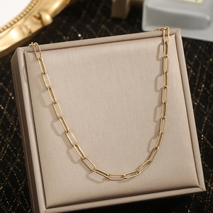 Minimalist 18K gold plated paperclip chain necklace on a champagne display stand