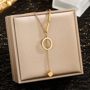 Detailed close-up of gold Y-shaped necklace with rectangle pendant on jewelry box