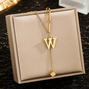 Detail of gold letter W pendant with square charm on a fine stainless steel chain